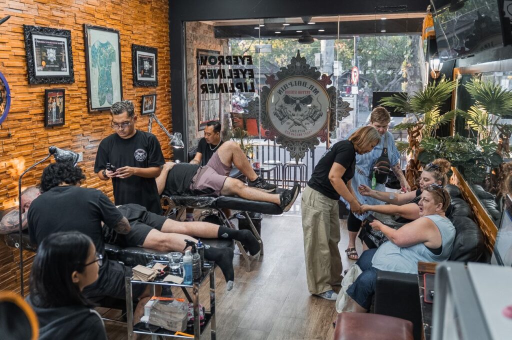 Tattoo artist discussing a custom design with a client at MR Dolphin Tattoo