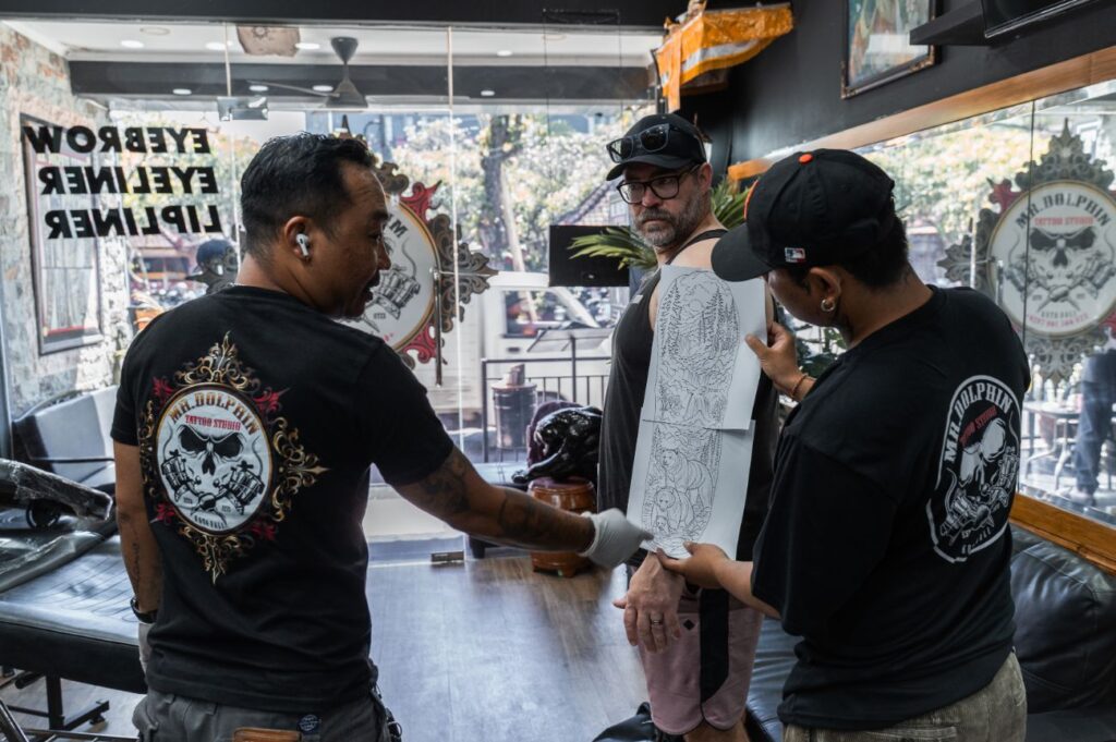 Tattoo artist developing a custom tattoo design with a client in Bali